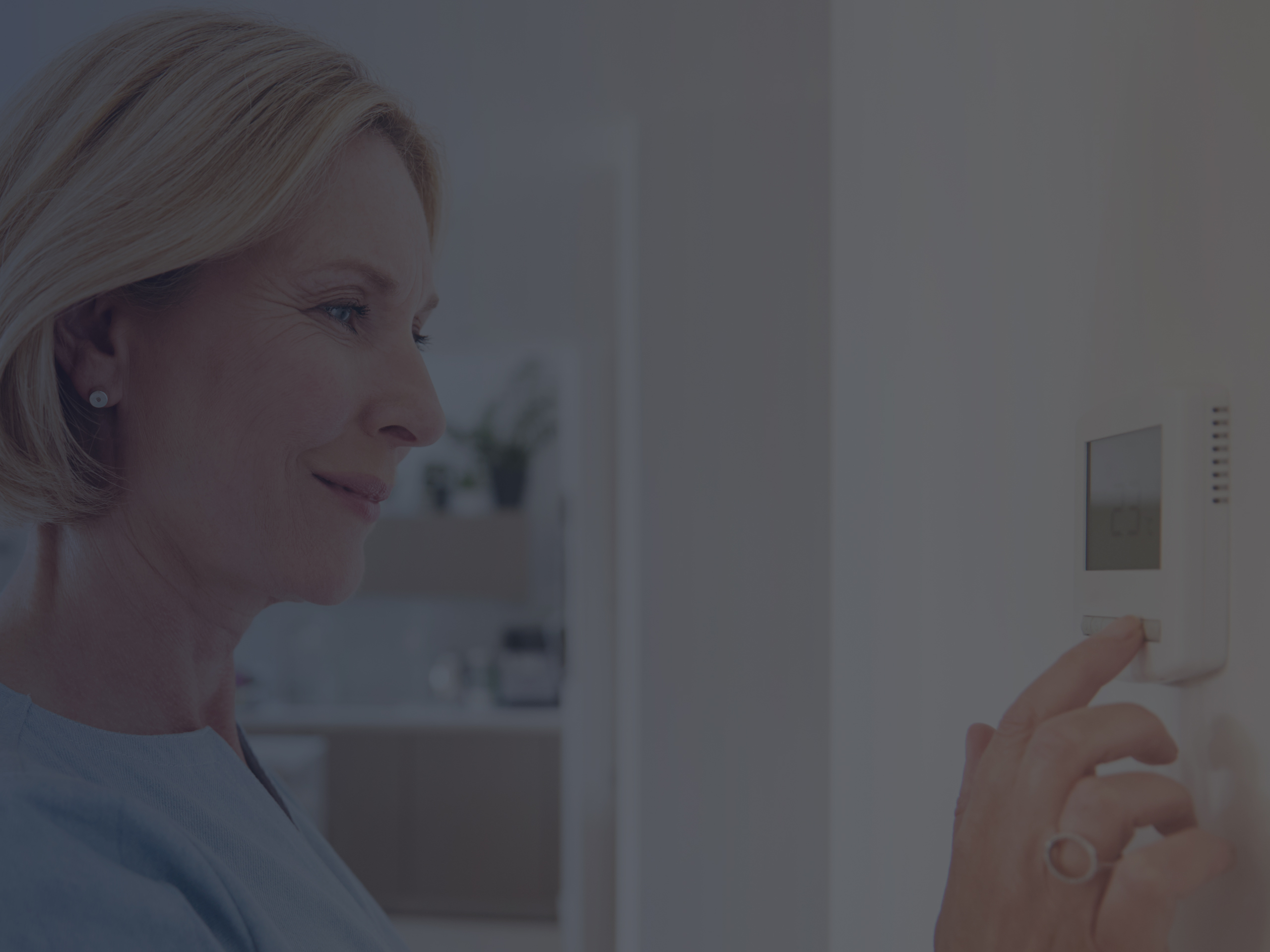 Close Up Of Mature Woman Adjusting Central Air Conditioning System