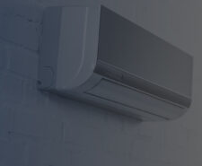 Close-up Shot of Grey Air Conditioner Hanging on White Brick Wall