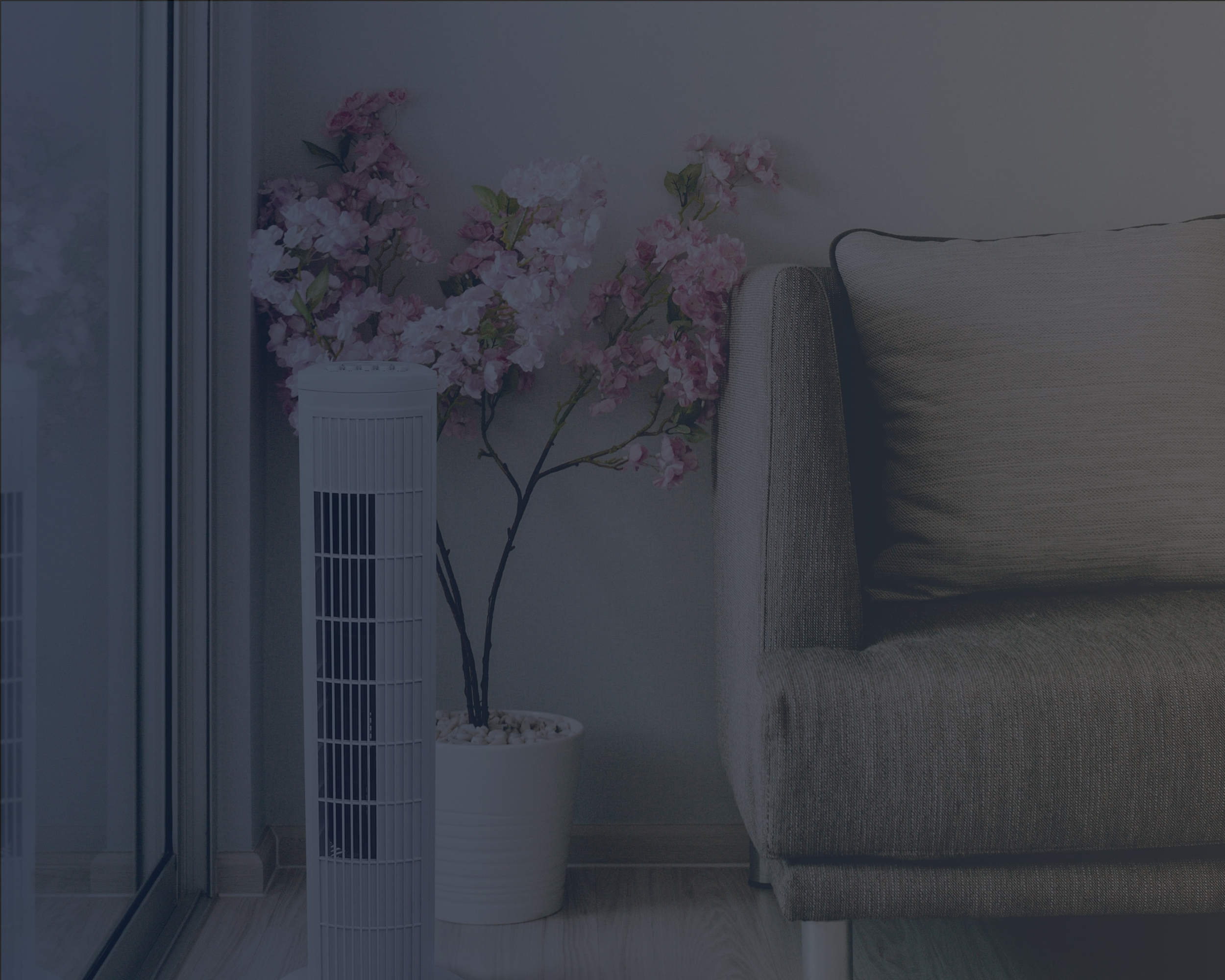 Tower Fan on the Floor in Front of a Vase with Pink Flowers in Living Room