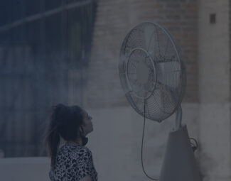 Woman Standing in Front of Misting Fan Outside