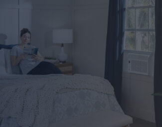 Woman in Bedroom Reading Book with Window AC Turned On