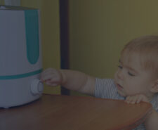 Little Girl Trying to Turn on a Humidifier in the Bedroom