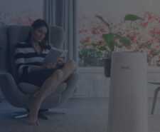 Woman Reads a Book while Air Ionizer Cleans Indoor Air