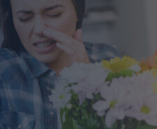 Young Woman Holding a Bouquet of Flowers and Sneezing