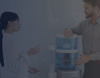 Colleagues Interacting next to a Water Dispenser and Cooler